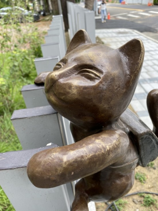 半夢(mèng)半醒的貓咪攀牆上學(xué)，摹寫著孩童們匆忙上學(xué)的日常，藝術(shù)家─曾永玲發(fā)揮天馬行空的想像投設(shè)其中。