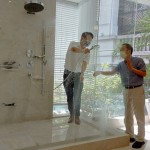 新業(yè)建設(shè)卓勝隆董事長(zhǎng)（右）伸手測(cè)試三段式水流變化為肌膚帶來(lái)的觸感，親身體驗(yàn)，精選出舒心的衛(wèi)浴設(shè)備。