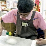 將羊毛絮包覆到皂體上，接著在每一面都進行「氈濕」的程序，讓原本輕盈的羊毛吸收水分後重量增加與皂體緊密貼合，使羊毛皂更好地同時達到滋潤肌膚與去角質的作用。