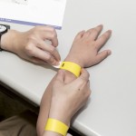 活動(dòng)開始之前，工作人員協(xié)助大、小朋友們戴上分組的幸運(yùn)手環(huán)。