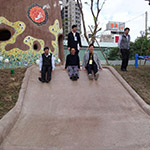 新業(yè)建設卓勝隆董事長(中)與來賓童心大發(fā)，一起玩溜滑梯。