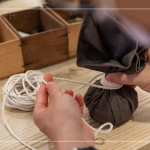 抓取藥材，包起、壓緊、編綁成球，感受草本植癒之外，還增添了另一份手感溫度，透過捶打、按壓，舒緩疲勞、釋放壓力。