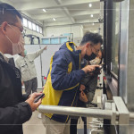 營建部工地主任-吳瑞隆(圖中)，用燈源檢查水密性能試驗後的氣密窗，確認是否有漏水、滲水或濺水的情形。