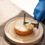 半硬質(zhì)家族的修道士(TETE DE MOINE)，呈小型鼓狀，外殼有點油膩、呈褐色，乳酪團結(jié)實且濃郁，隨著熟成顏色會加深，以轉(zhuǎn)臺式乳酪削切器，削成花摺邊小花苞。