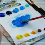 飽和多彩的顏料，在紙製調(diào)色盤上，用畫筆輕輕均勻塗開，準(zhǔn)備在素色畫布上恣意揮灑。