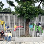 築起一座座小小的山丘，承載著各類小動物們，將一面泥灰的牆面賦予繽紛的生命力，並傳達『生命關懷、愛物惜物』的感恩之心給所有孩子們。(圖中間為藝術家張婷雅)