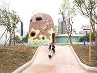 新業(yè)建設(shè)董事長(zhǎng)卓勝隆童心大發(fā)，在碉堡地景溜滑梯。