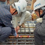 由新業(yè)建設名譽董事長穆椿松先生（圖左一）、卓勝隆董事長（圖右一）一同親手將主角「噴金漆鋼筋」綁紮、安置於屋頂中樑位置，代表著建築的穩(wěn)定與安詳。